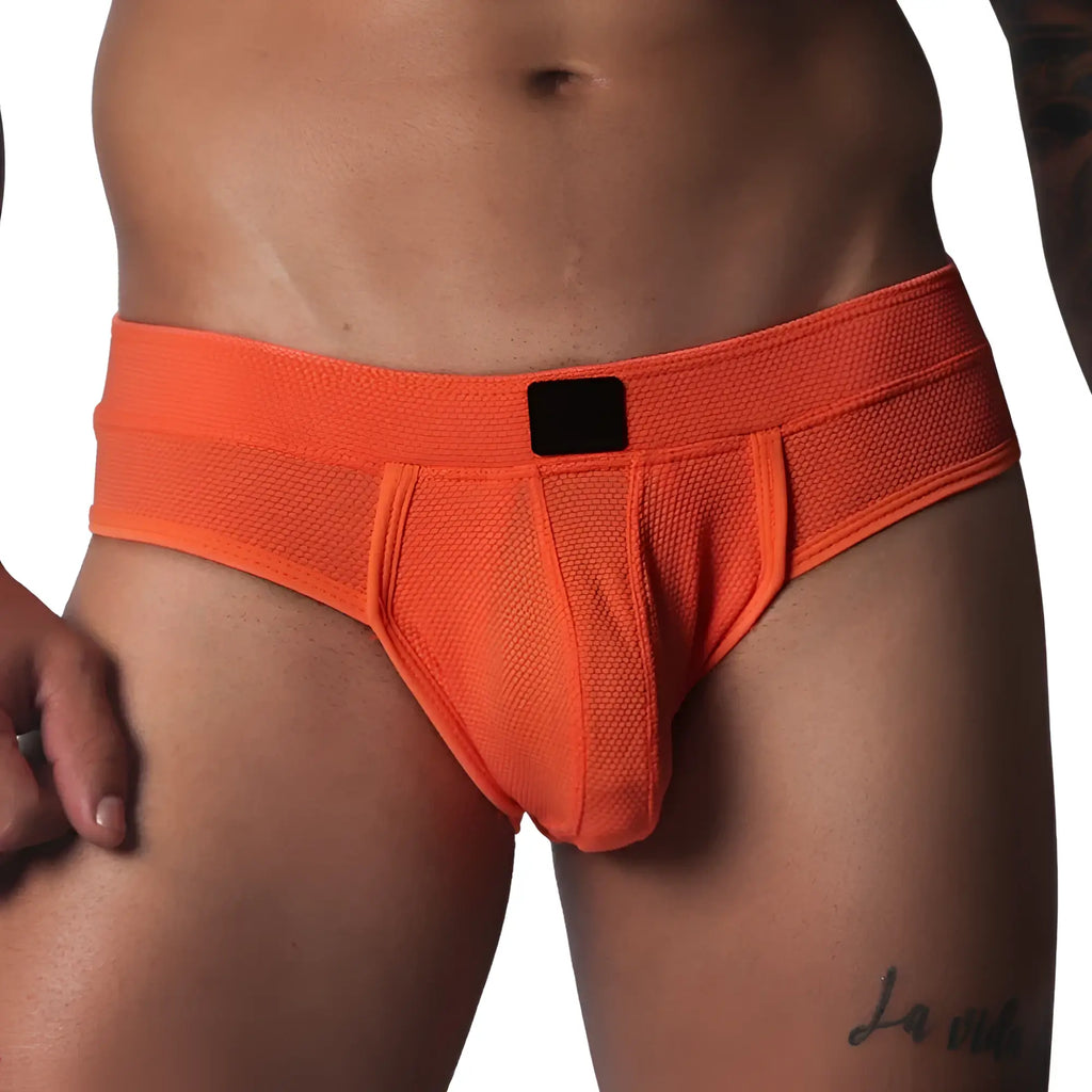 Bright orange athletic jockstrap made of textured honeycomb fabric with a solid black center label on the waistband.