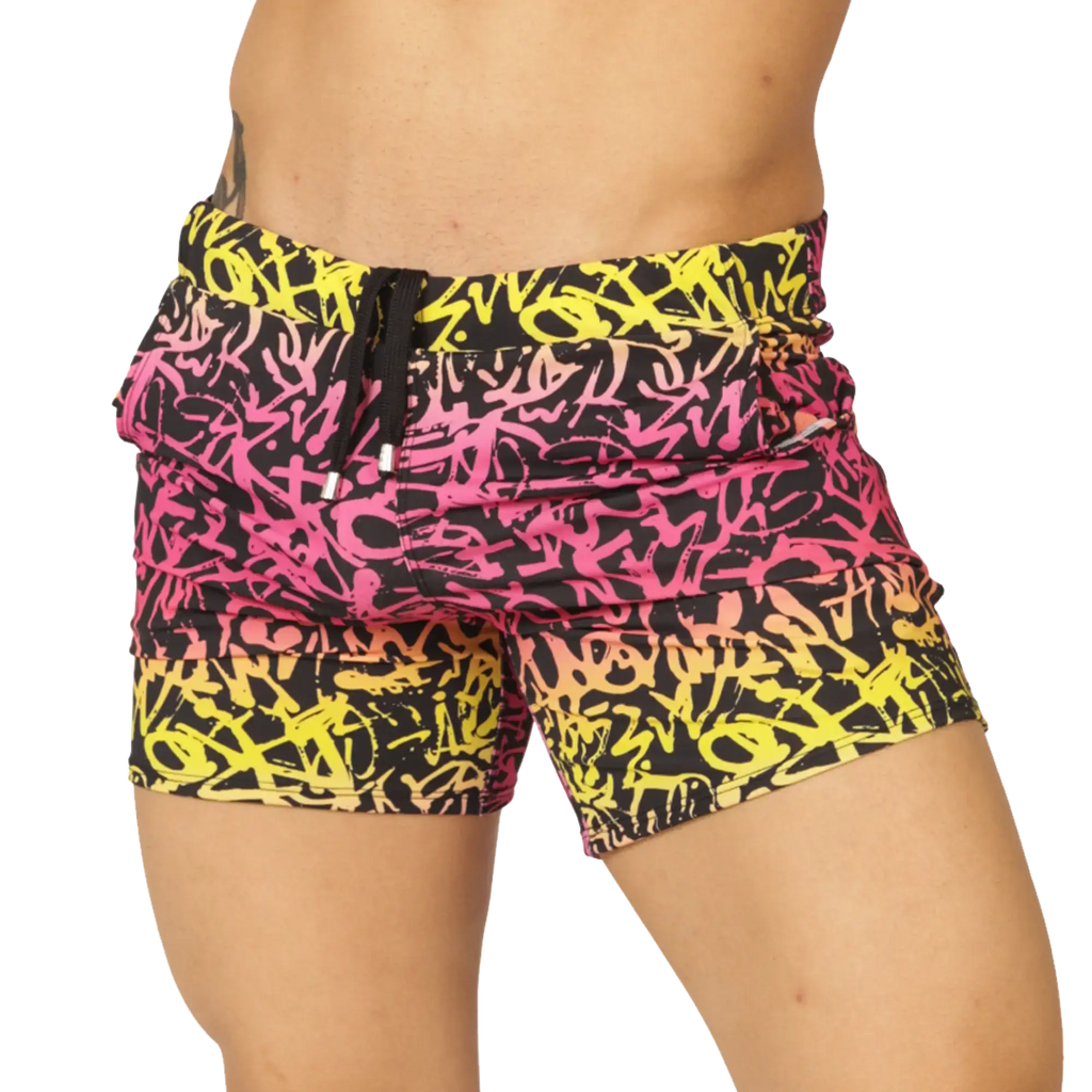Gigo Crazy Beachwear vibrant graffiti-patterned swim shorts in bold pink yellow and black with drawstring waistband