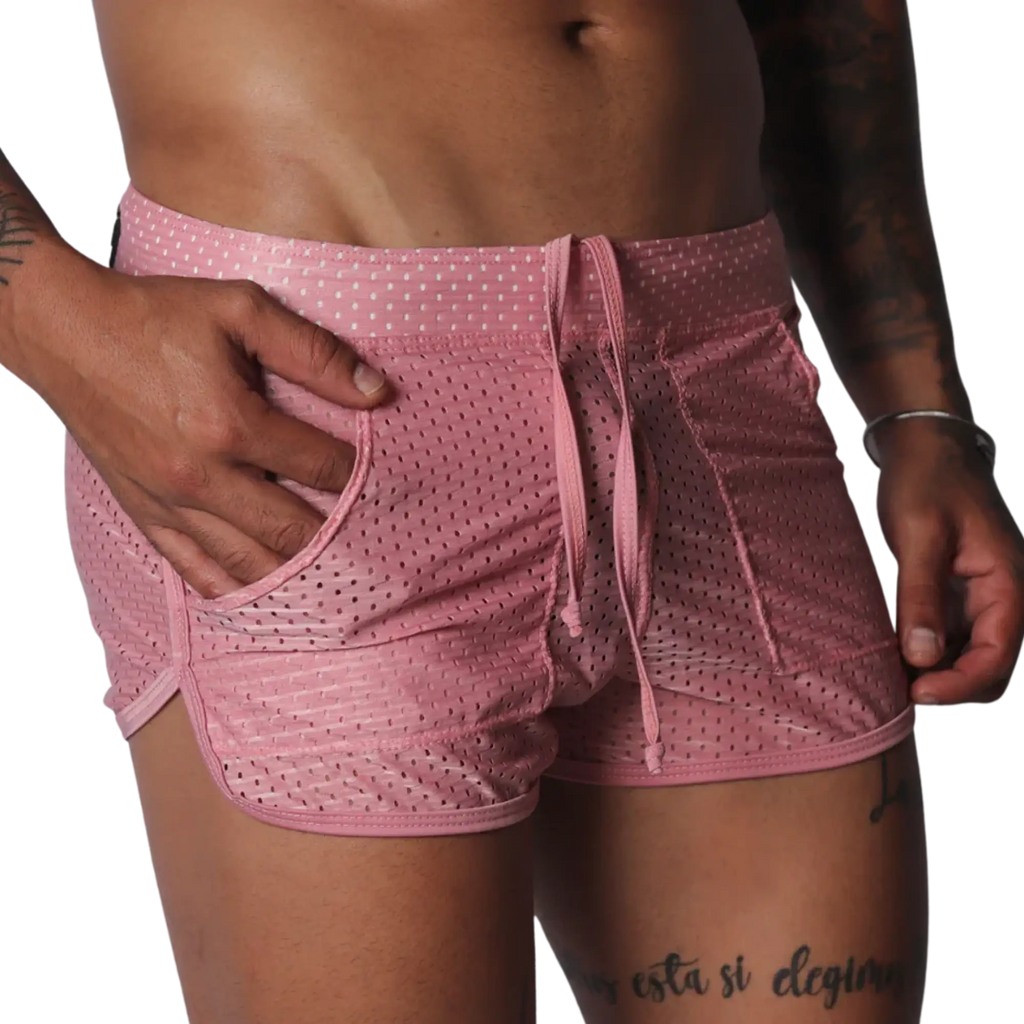 Pink, mesh athletic shorts with a drawstring waistband, side pockets, and curved hem detail.
