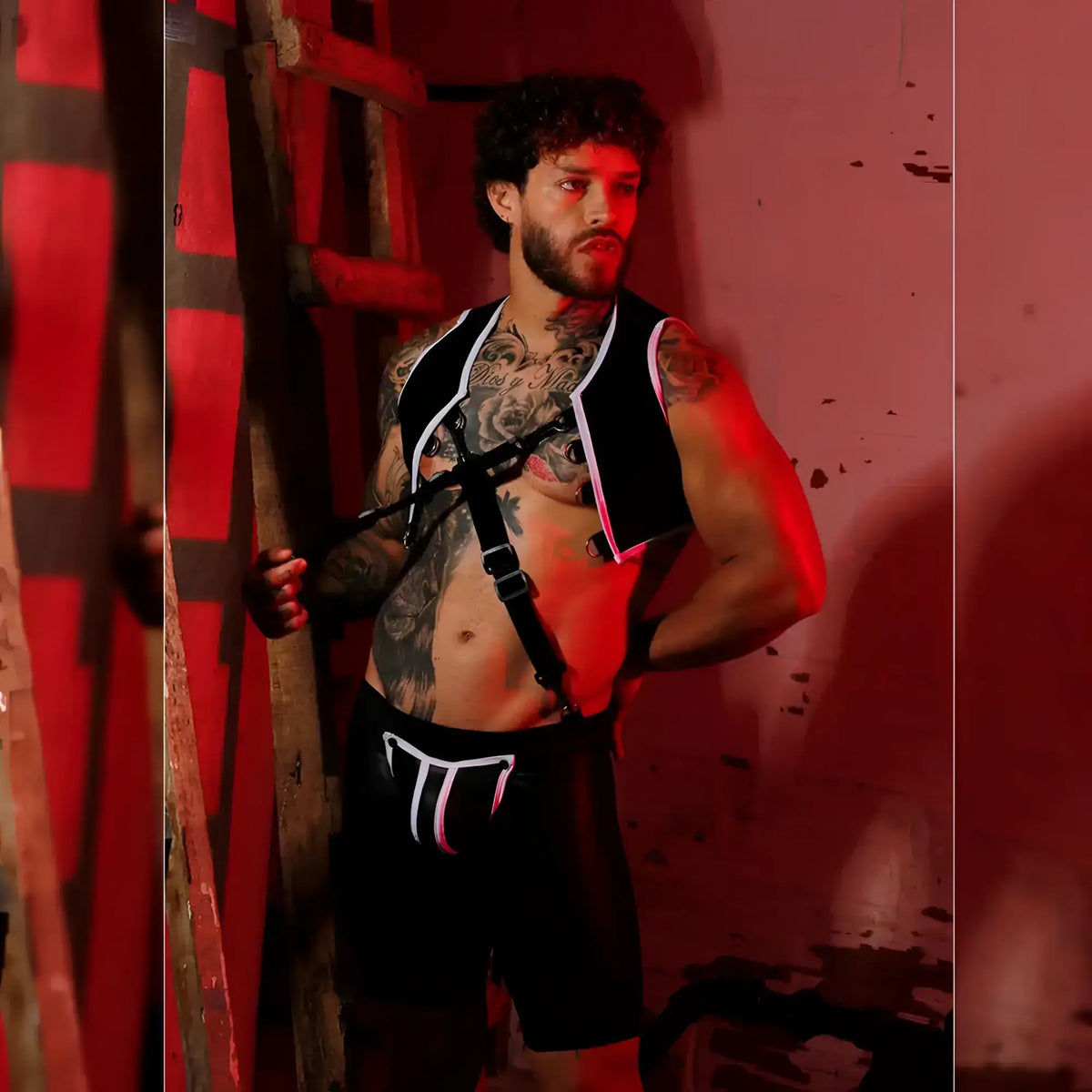 Black and white tactical vest with adjustable straps worn over tattooed torso in gigo f fetish white trunk long product image