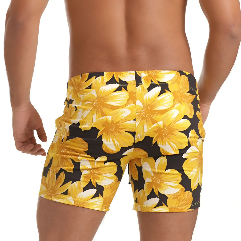 Gigo flowers yellow beachwear swim trunks with bright yellow tropical flower pattern on black background