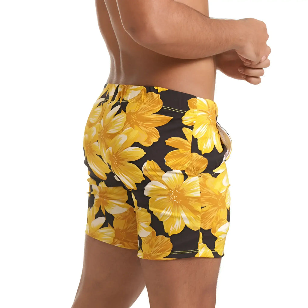 Black swim trunks with bold yellow floral pattern and white accents from gigo flowers yellow beachwear collection