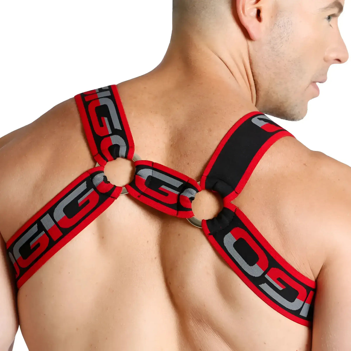 Red and black elastic straps with silver gigi lettering form a cross-back gigo karma black harness on the back side