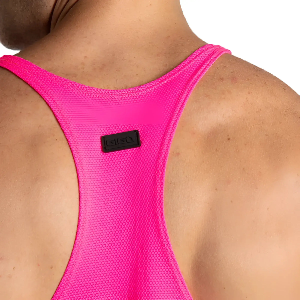 Bright pink mesh racerback sports bra with black rectangular brand tag from gigo lemon fucshia tank collection