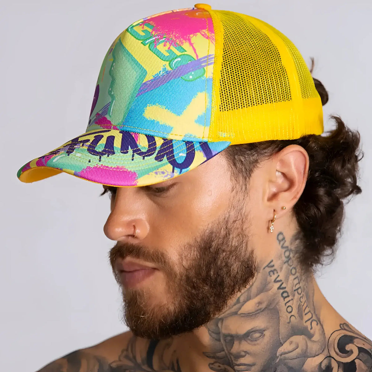 Vibrant graffiti-style gigo neon yellow caps trucker hat with yellow mesh back and bold pink blue green purple paint splatter