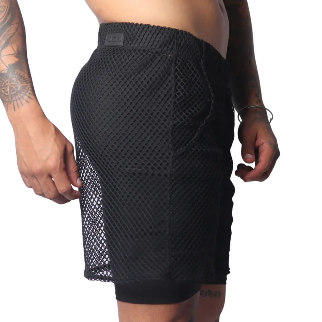 Black athletic shorts in a large-grid fishnet material with a solid inner layer and a branded elastic waistband.