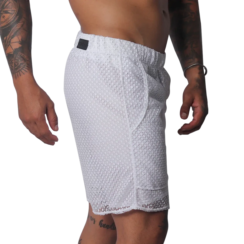 White athletic shorts made of a sheer, open-mesh material with an elastic waistband and small black logo patch.