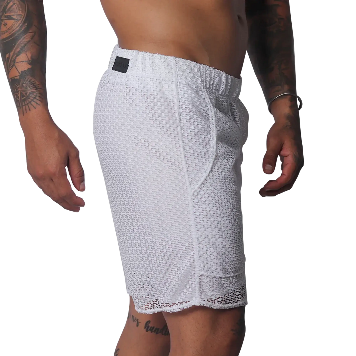 White athletic shorts made of a sheer, open-mesh material with an elastic waistband and small black logo patch.