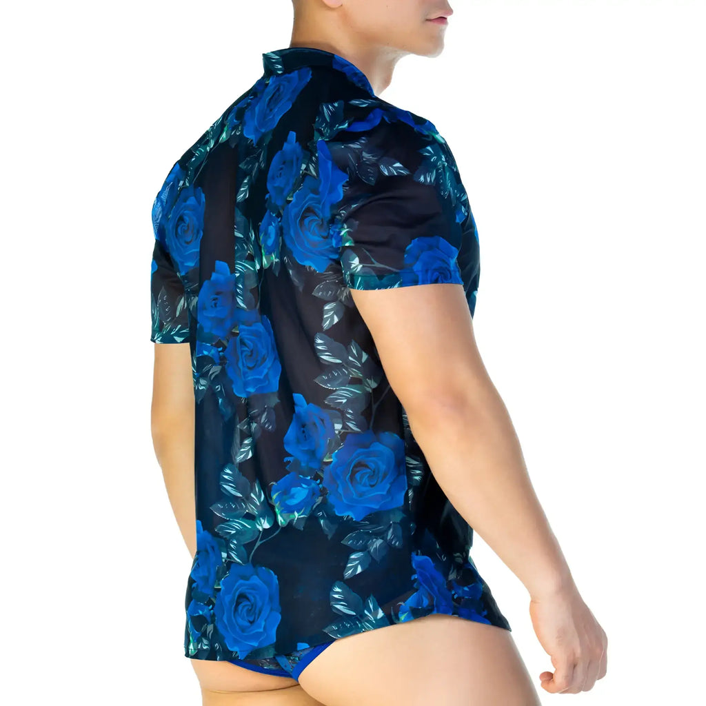 A man wearing a gigo rose blue shirt with vibrant blue rose and leaf patterns on sheer dark navy fabric