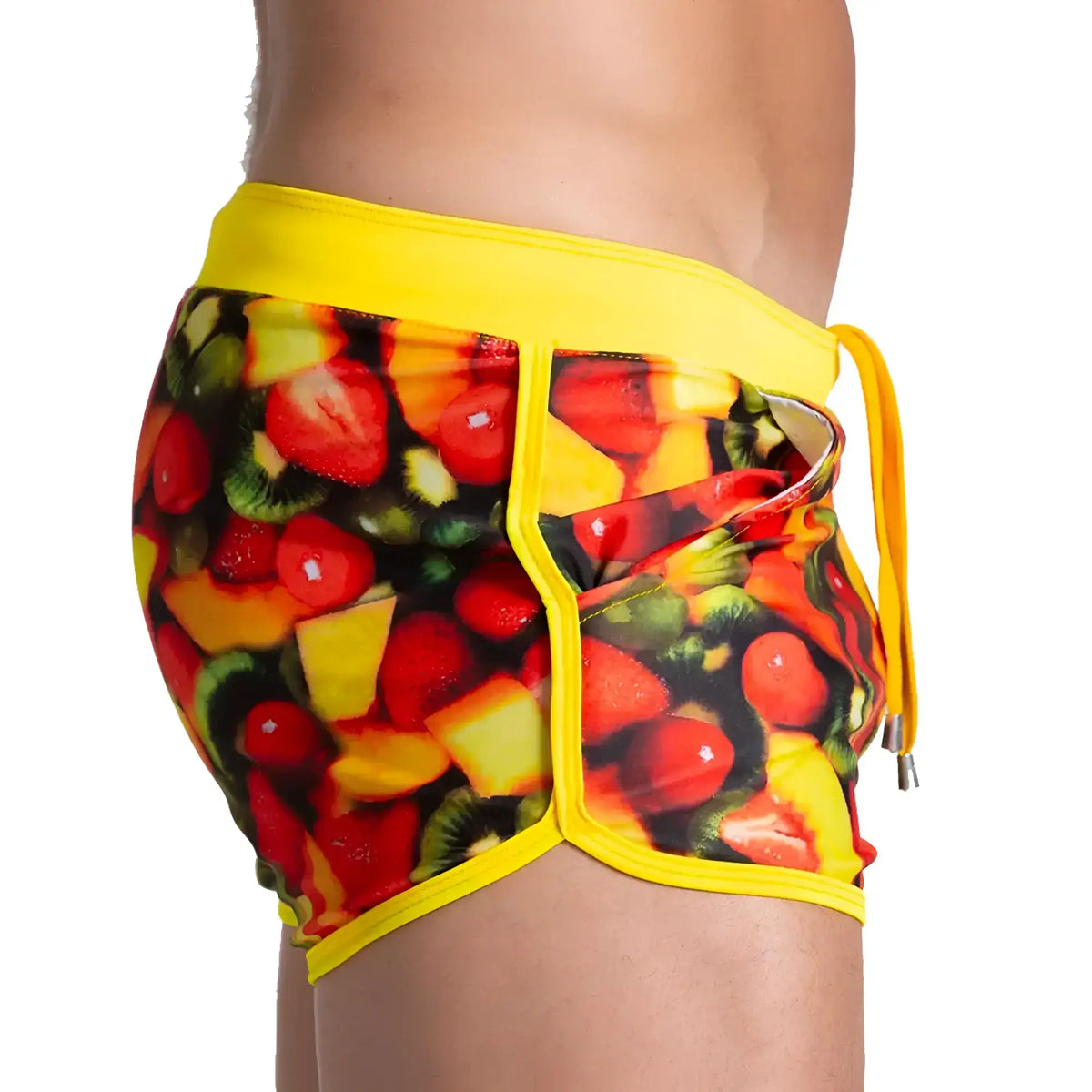 Gigo Salad Beachwear vibrant yellow swim trunks with bold colourful strawberry kiwi melon print on dark background