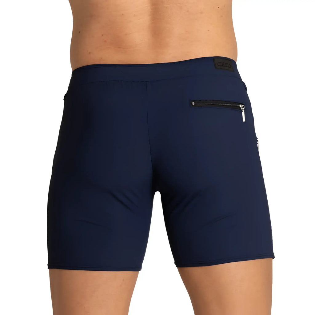 Back view of navy blue gigo tennis shorts with a zippered pocket and brand patch on the waistband