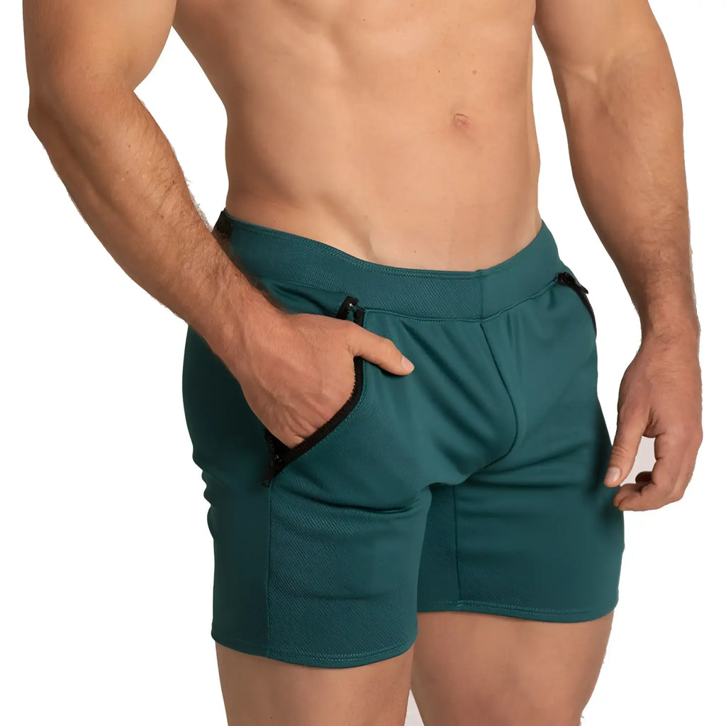 Teal gigo training green shorts with black zipper-trimmed side pockets and textured fabric finish