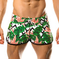 Gigo vintage beachwear swim trunks with tropical leaf and pink flower pattern and black zigzag accents