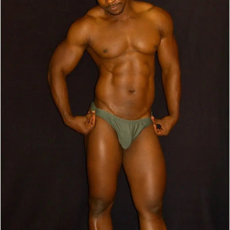 Olive green swimwear thong by Arroyman featuring a snug fit and minimal coverage modeled by a man.