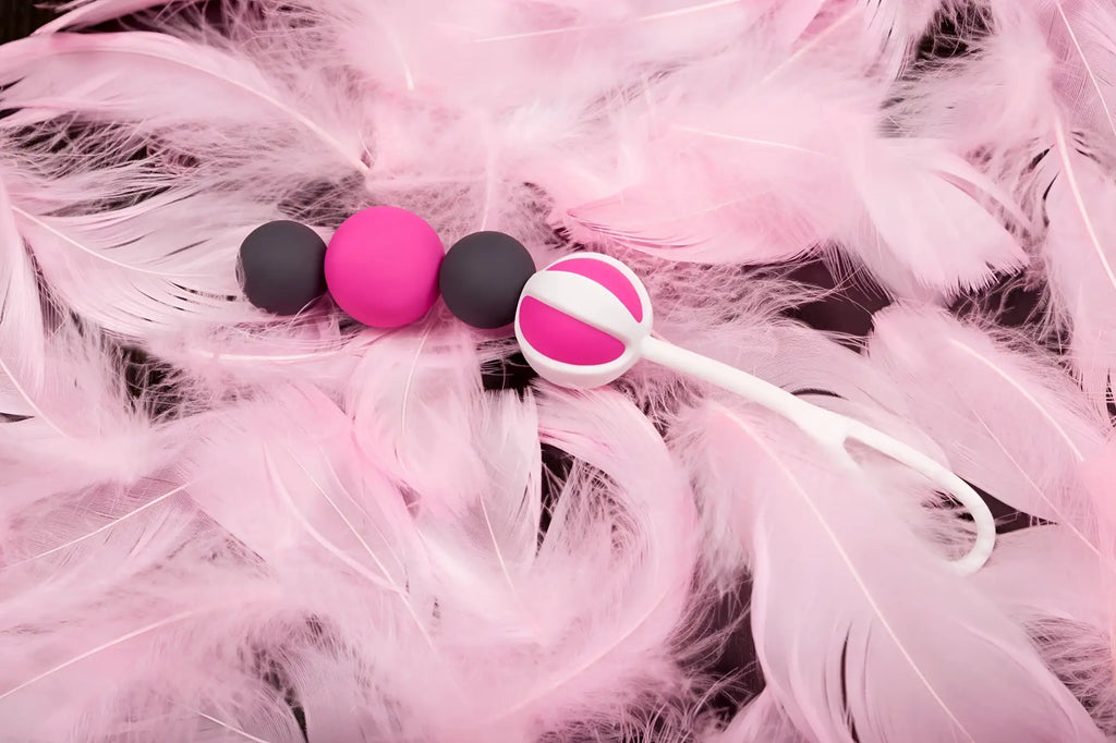 Pink and black silicone gvibe geisha balls magnetic egg train with a white handle for kegel exercises