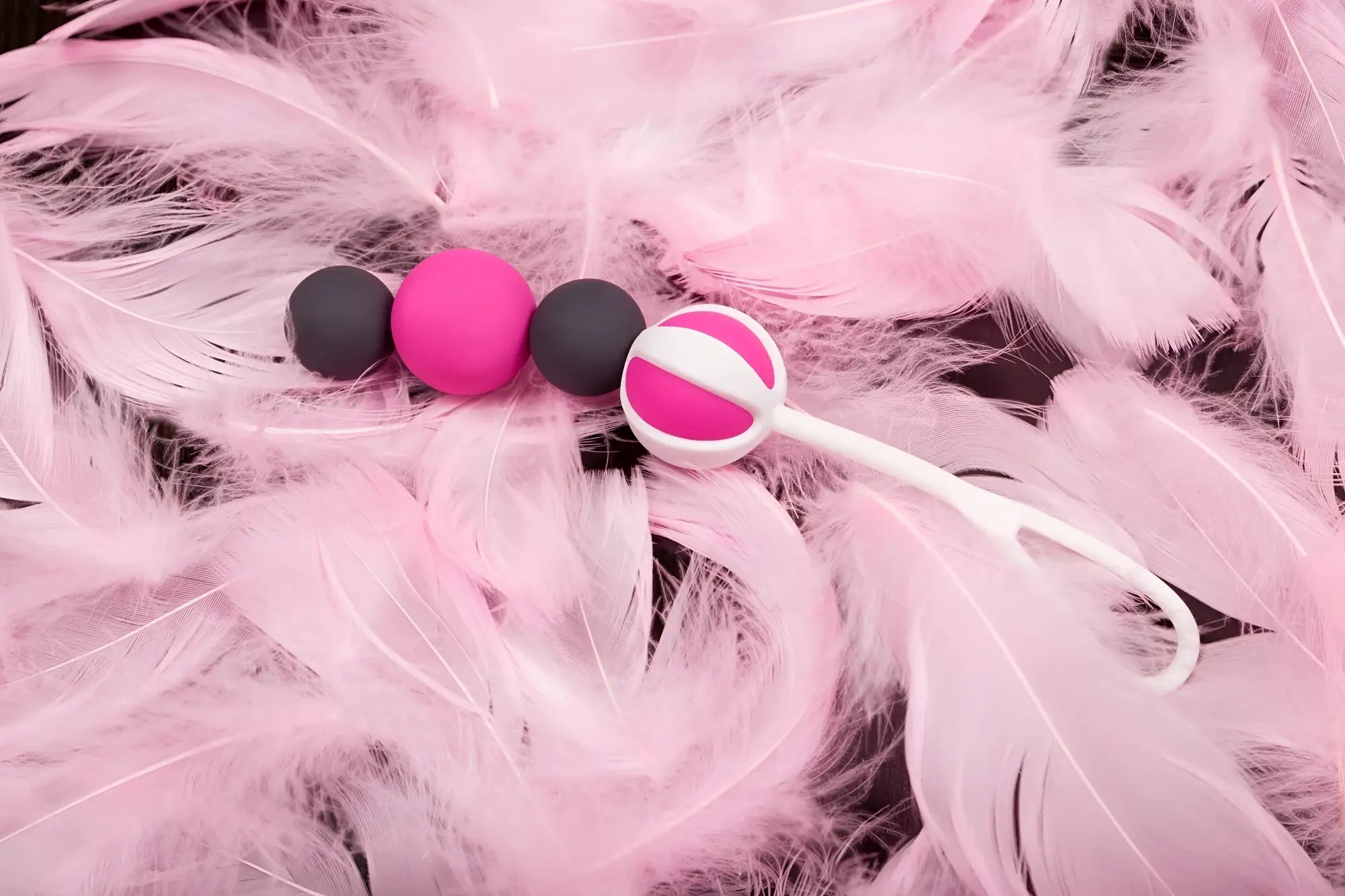 Pink and black silicone gvibe geisha balls magnetic egg train with a white handle for kegel exercises