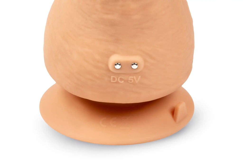Beige silicone suction cup with metallic contacts and dc 5v engraving on the back of gvibe greal flesh w suction cup