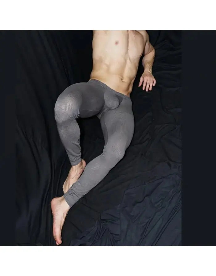 Men's grey mesh gym tights by Arroyman featuring a snug fit and breathable material shown on a model reclining.