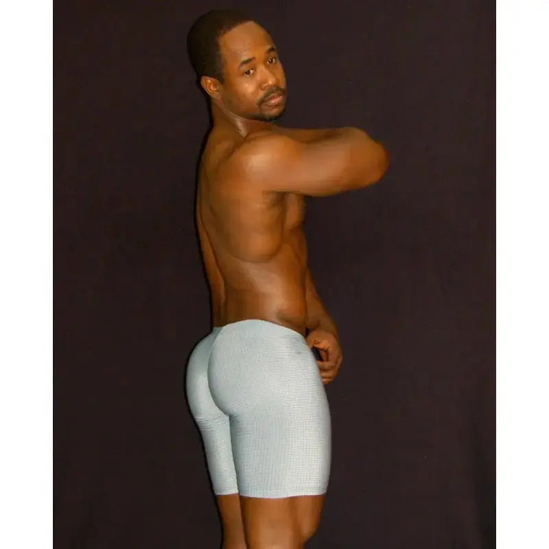 Men's gym short tights in light gray with a fitted design shown on a model from the side by Arroyman.