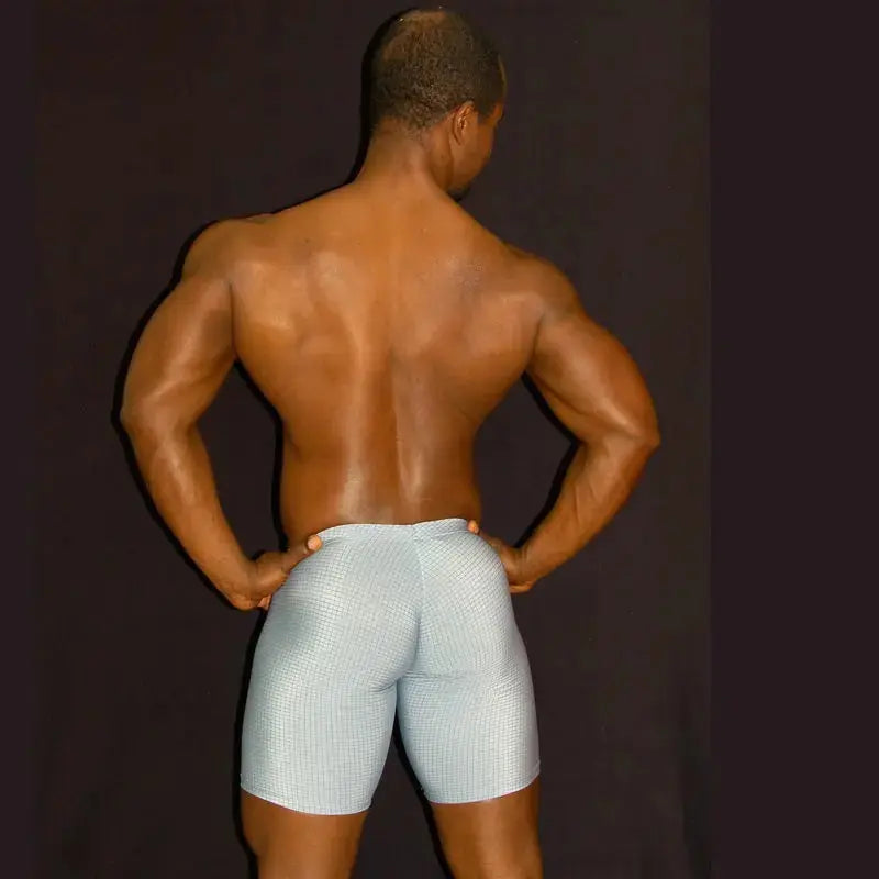 Men's gym bulge short tights in light blue with a checkered pattern shown on a model from the back by Arroyman.