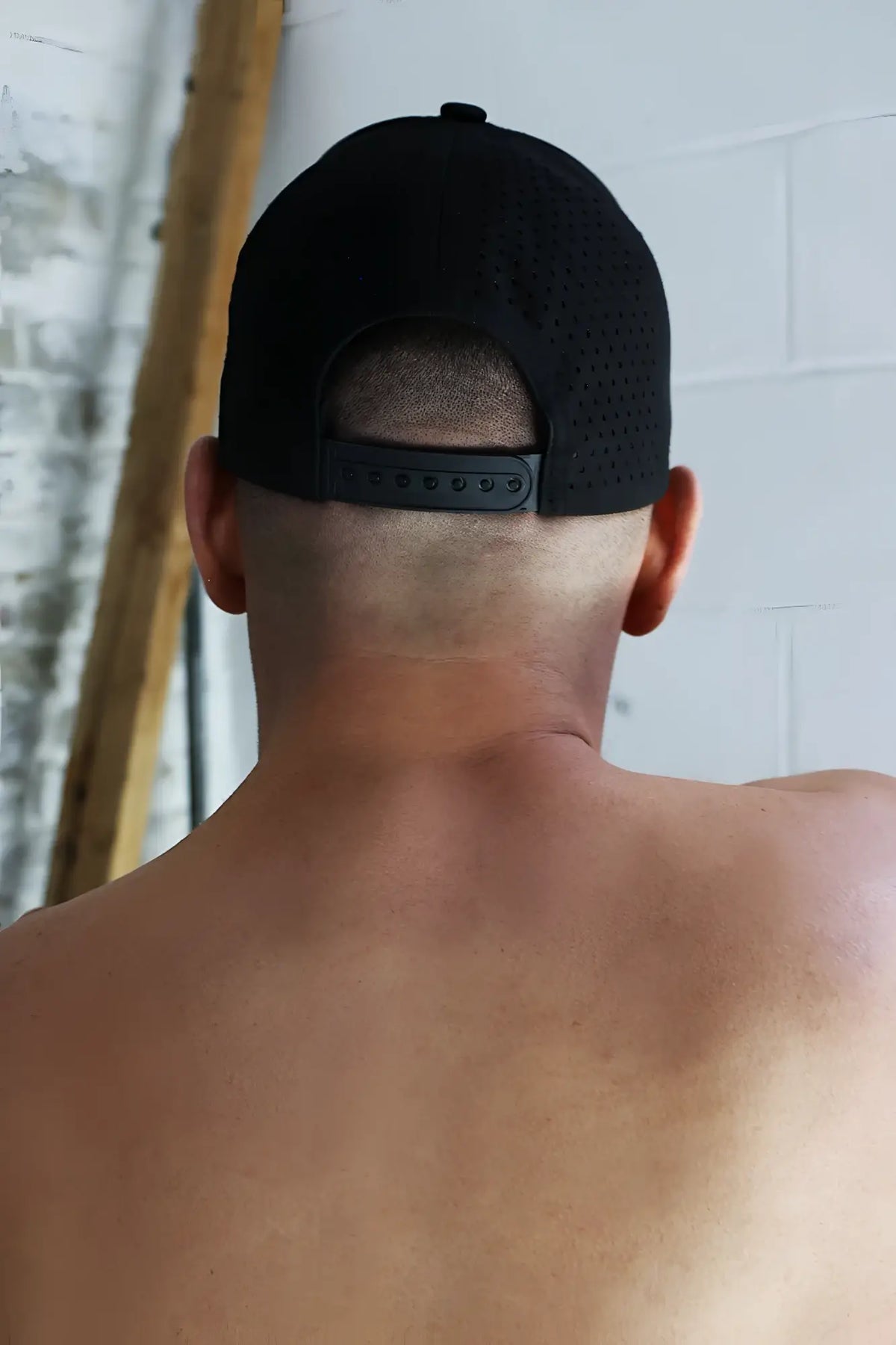 Black mesh baseball cap gymnetixxx hat with adjustable strap shown from the back for breathable comfort
