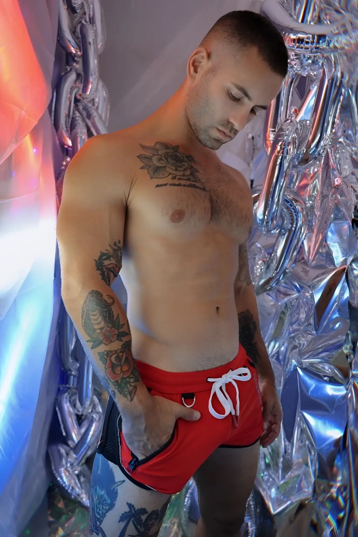 Red Gymnetixxx swim trunks with white drawstring and black trim designed for athletic use