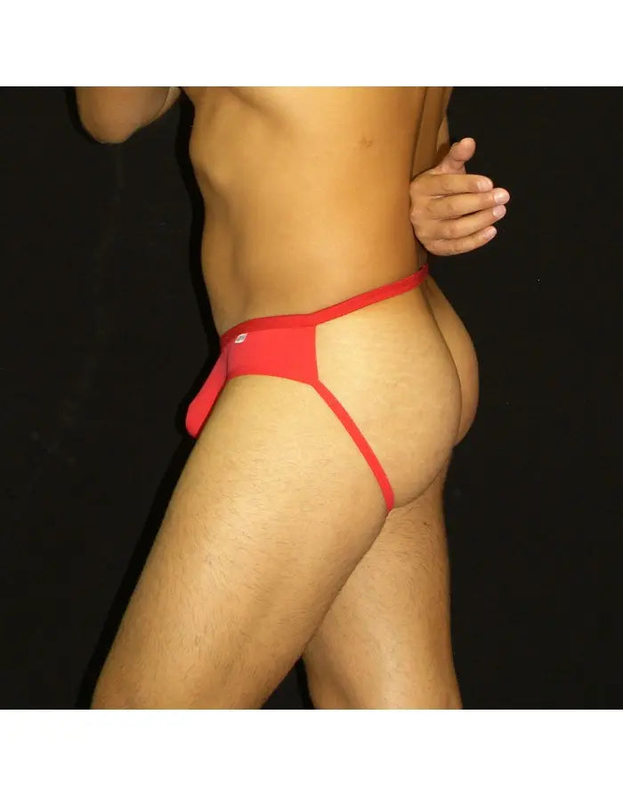 Red half bikini jockstrap underwear by Arroyman featuring a minimal design and elastic waistband shown on a model.