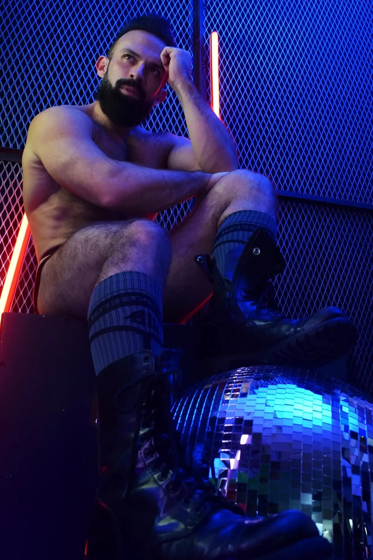A reflective disco ball with mirrored facets illuminated by blue and red lighting in hybrid socks product image