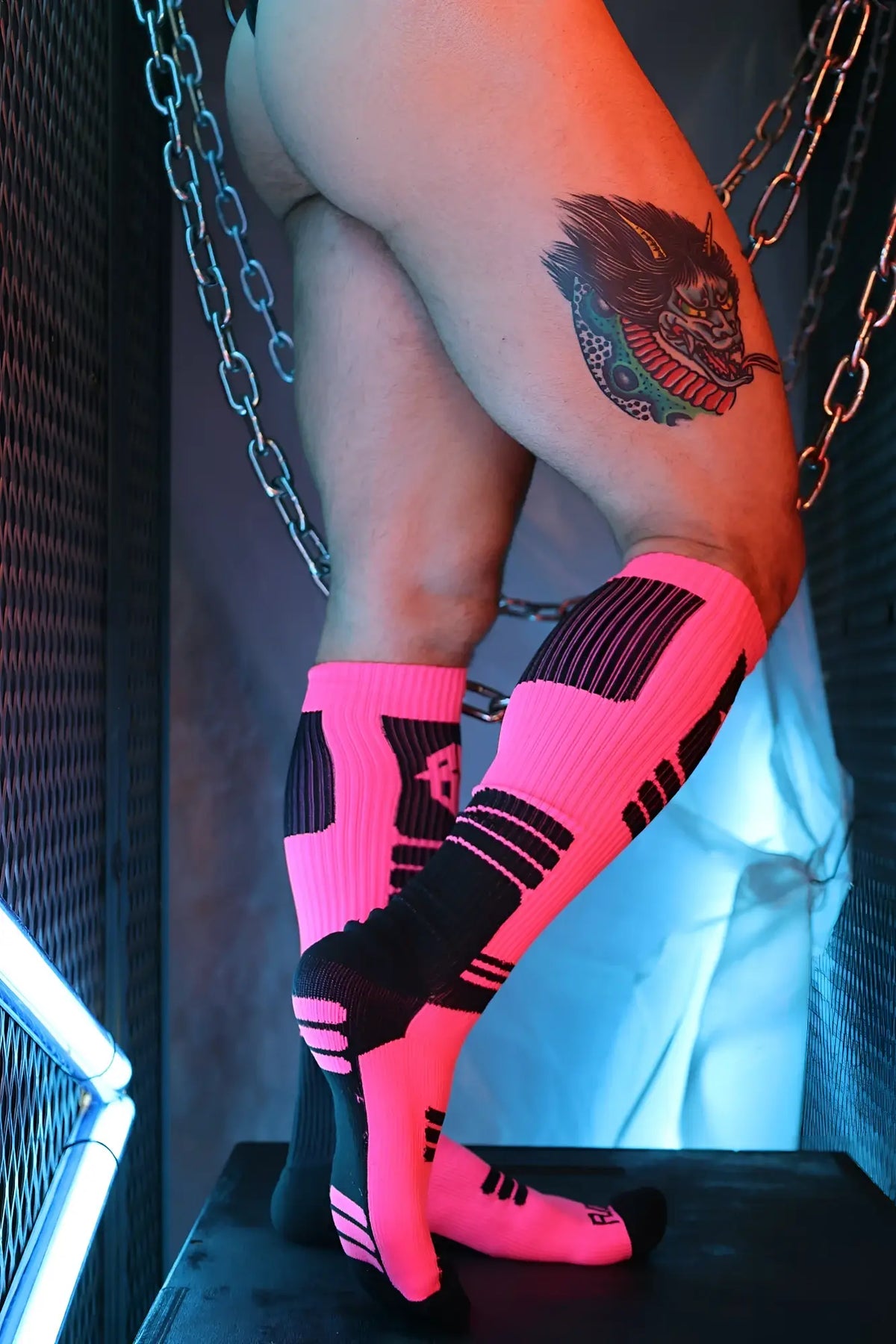 Neon pink and black athletic compression socks with bold geometric patterns designed for performance and support
