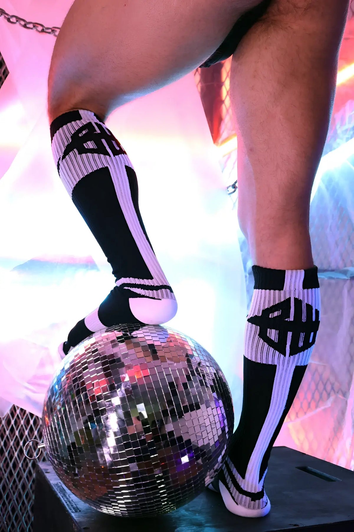 Black and white striped knee-high infinity socks with bold geometric logo design for stylish comfort