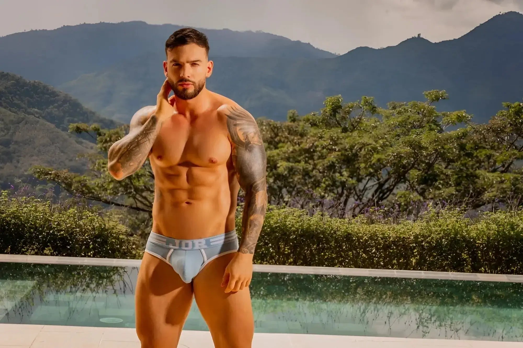 JOR 2321 College Briefs in blue, worn by a model in a front-view lifestyle shot by a pool.
