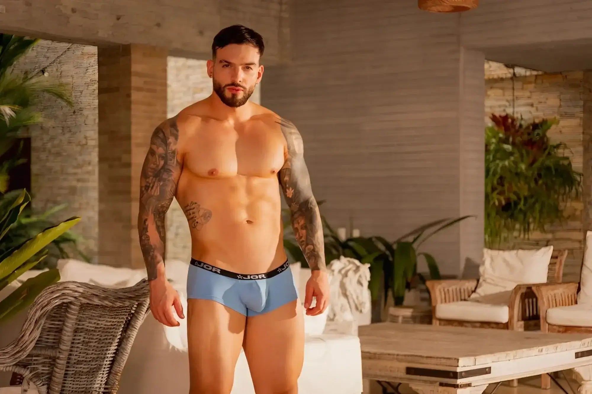 Lifestyle shot of a man wearing blue JOR 2345 Cannes trunks, front view.