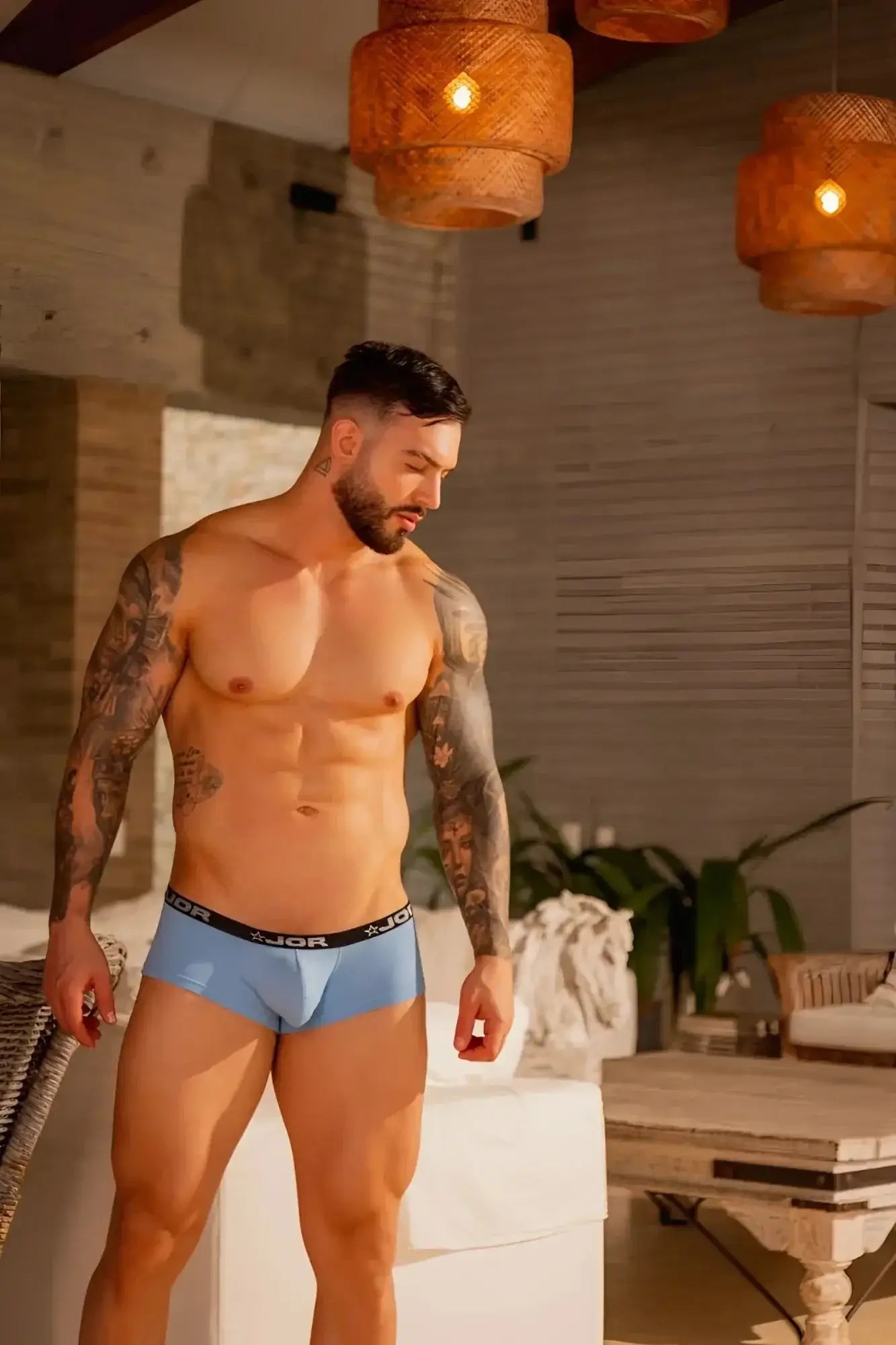 Lifestyle shot of a man wearing blue JOR 2345 Cannes trunks, front view.