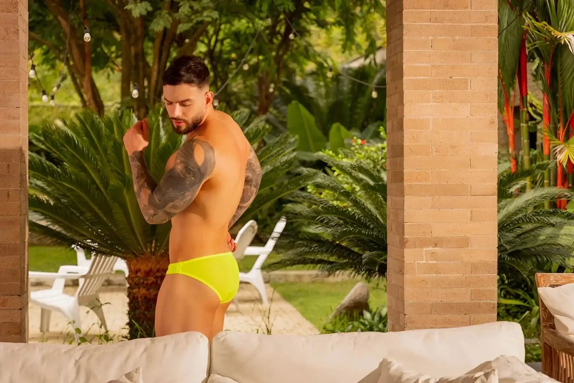 Lifestyle shot of a man wearing JOR 2353 Origin bikini in neon green.
