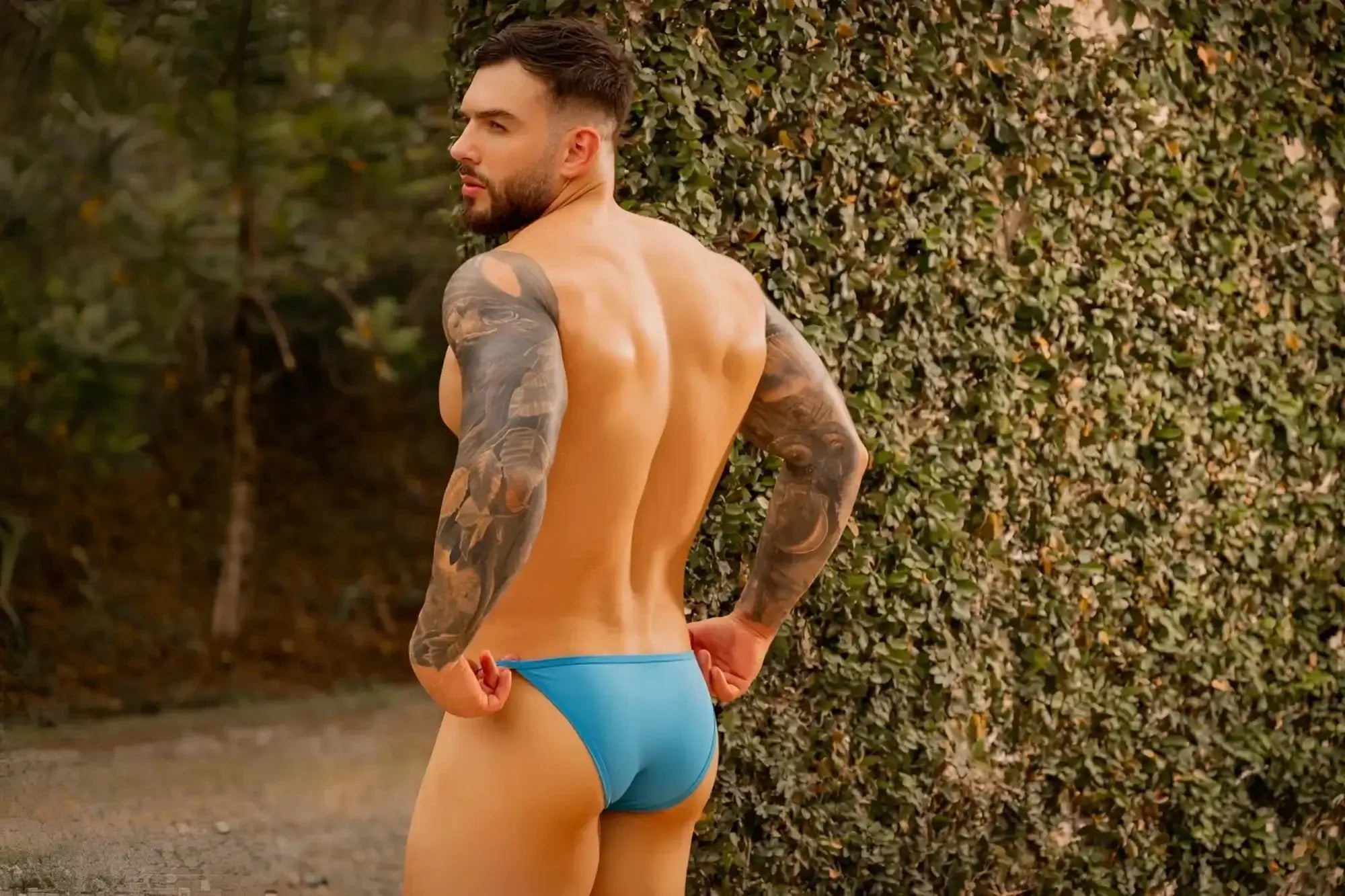 Lifestyle shot of a man wearing JOR 2358 Axel Bikini in turquoise, rear view.