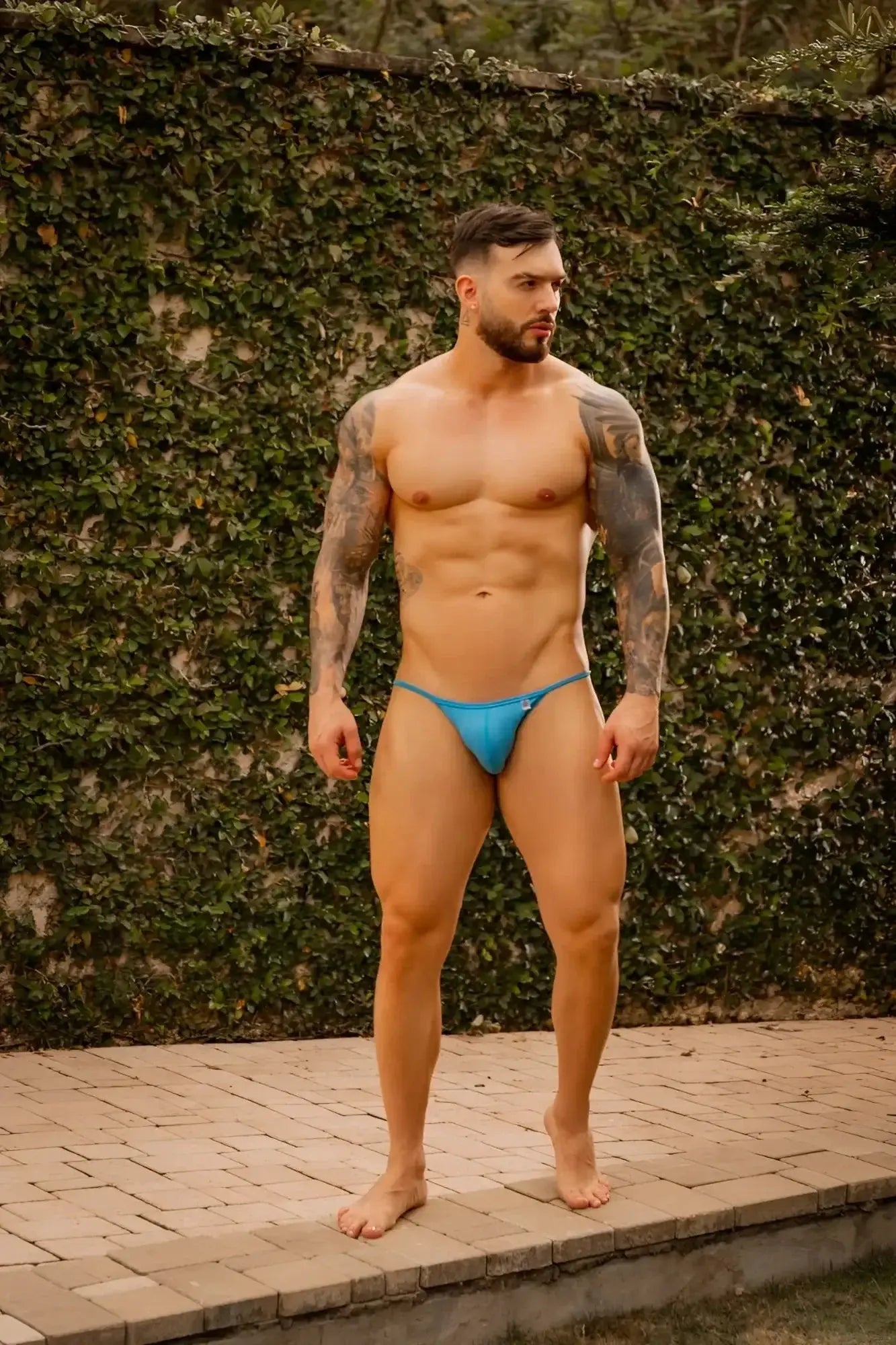 Lifestyle shot of a man wearing JOR 2358 Axel Bikini in turquoise, front view.