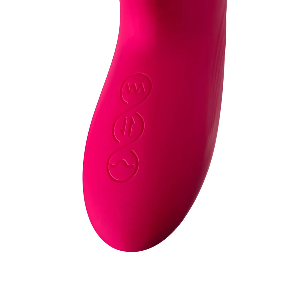 Bright pink silicone handle of jos jos seri thrusting vibrator with clitoral stimulator pad showing three embossed buttons