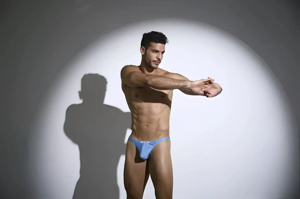 A man wearing justin simon xsj03 classic baby blue form-fitting briefs with a small white logo on the front