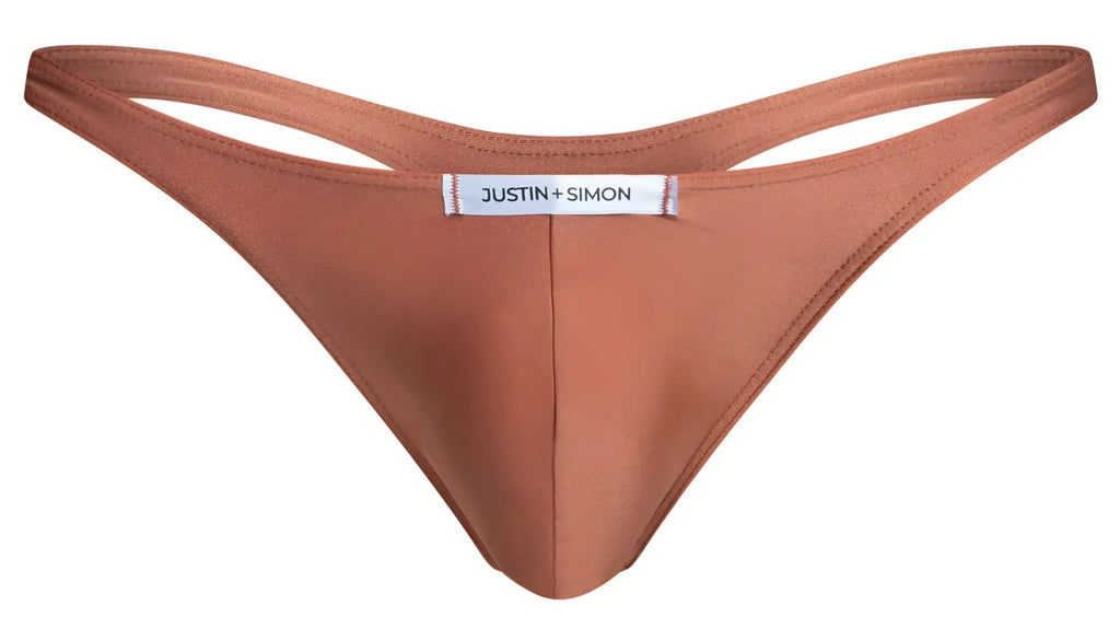 A sleek rust-colored smooth fabric thong with minimalist design and justin + simon label in the center