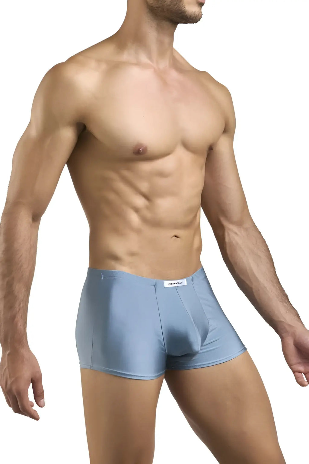 Light blue form-fitting boxer briefs with subtle textured fabric and a small white brand tag at the waistband by Justin Simon