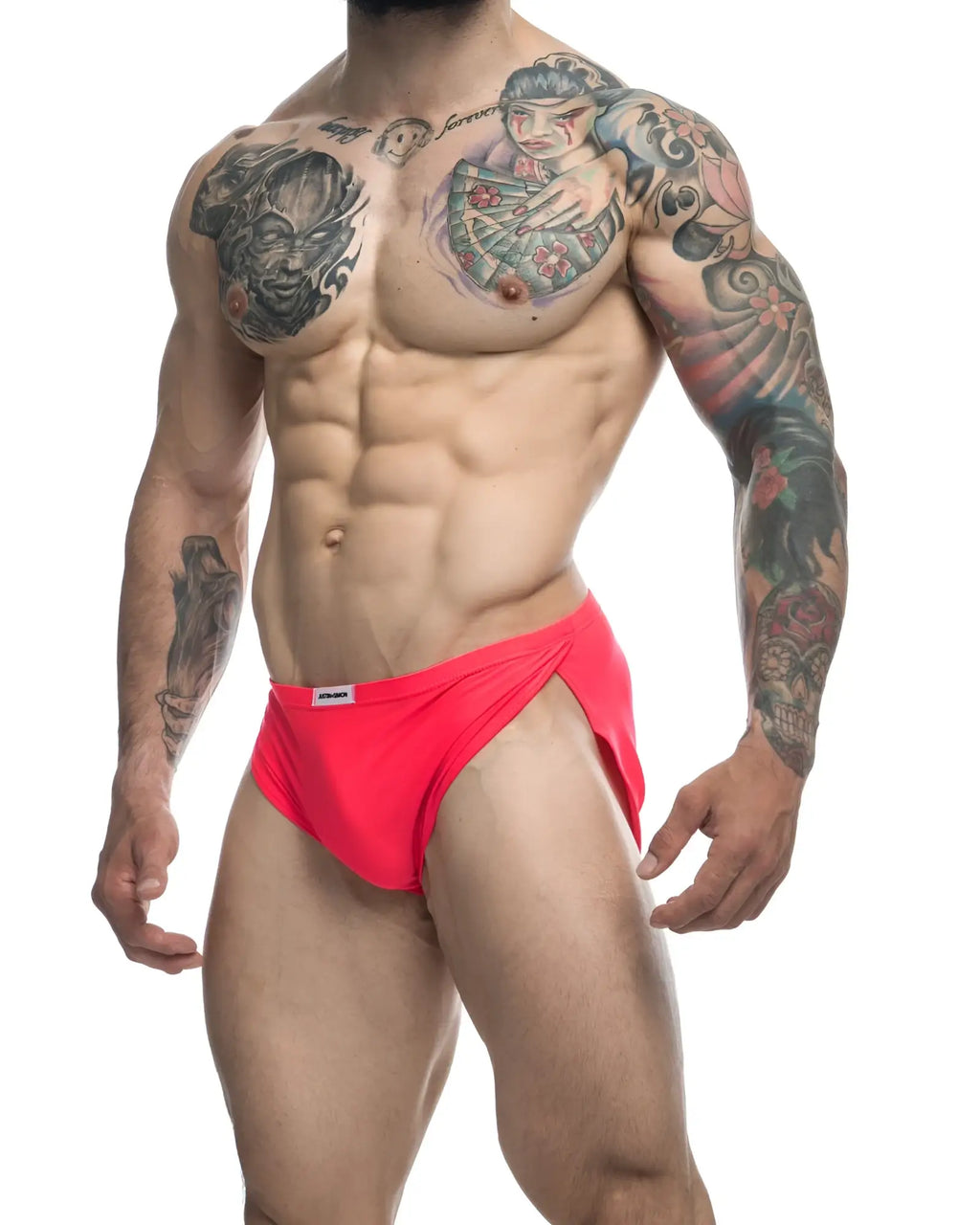 Bright red form-fitting swim trunks with a small white brand tag on the waistband from justin simon xsj09 coral collection
