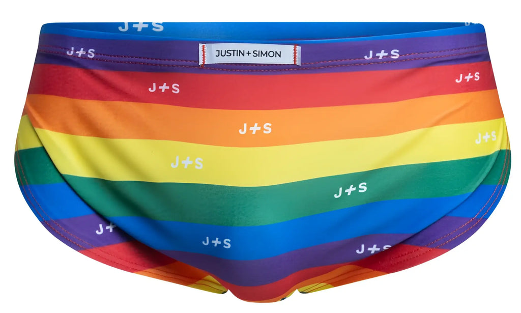 Rainbow-striped men’s briefs by justin+simon with repeating white j+s logo in pride flag colors for running use