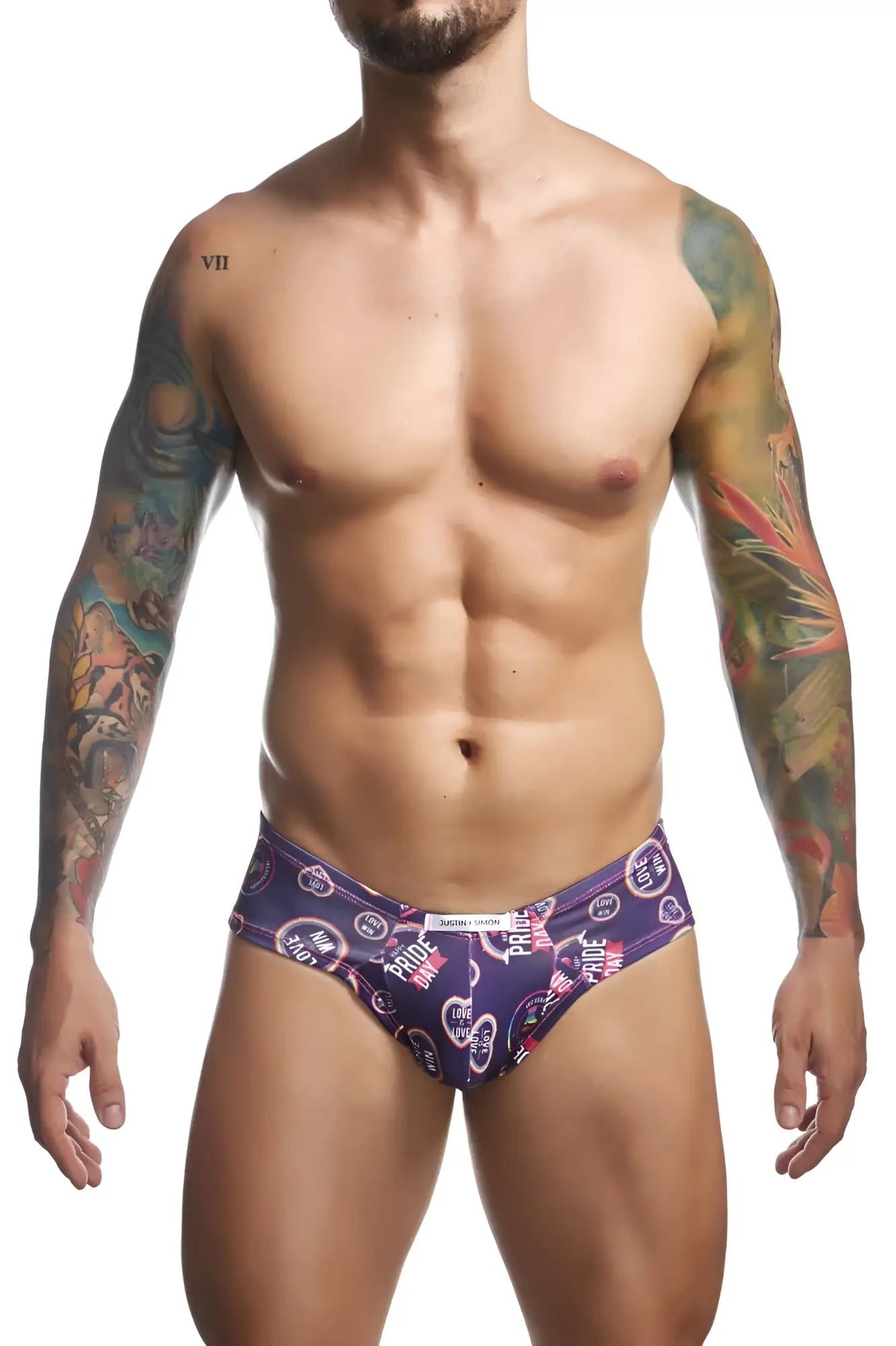Purple patterned men’s briefs by justin simon featuring hearts and pride text in pink white and black vibrant design