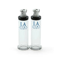 Two transparent glass la pump nipple enlargement cylinders with black caps and silver pump mechanisms 16mm diameter