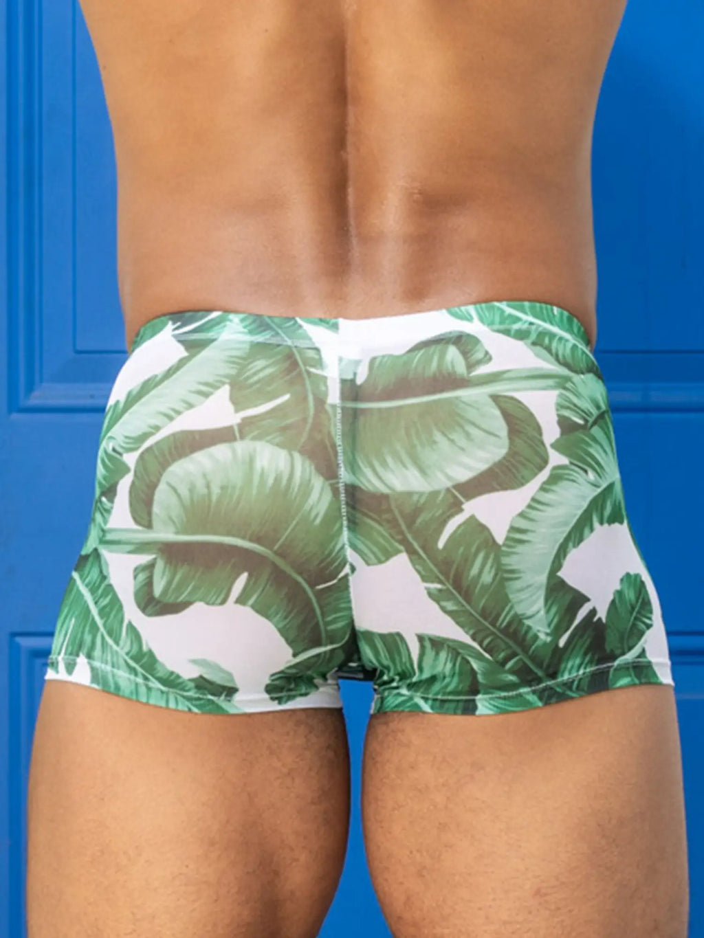 Little boy blue design chris square cut mesh swim trunks with green banana leaf pattern on white background