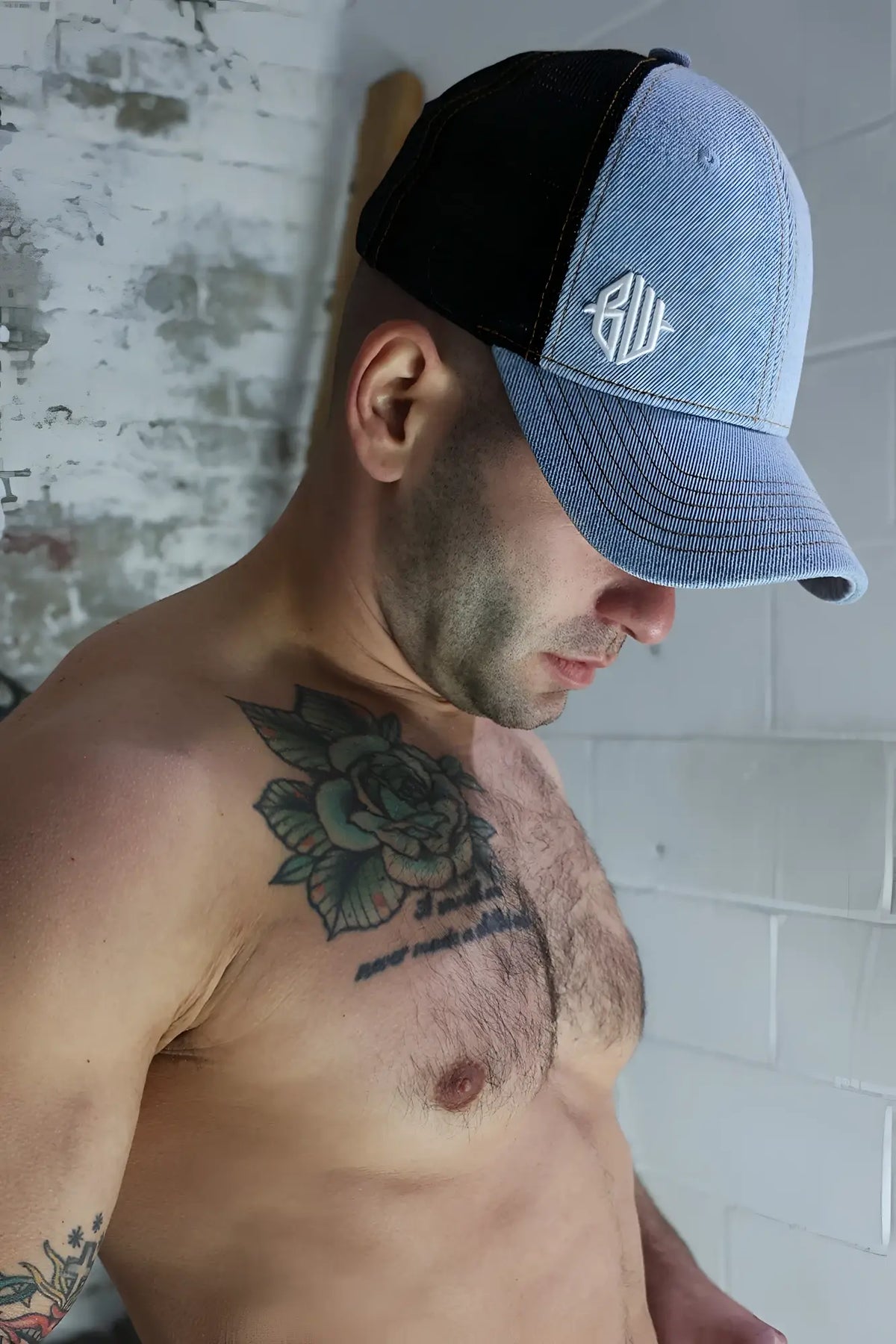 Blue and black loaded denim trucker hat with white embroidered logo on the front panel
