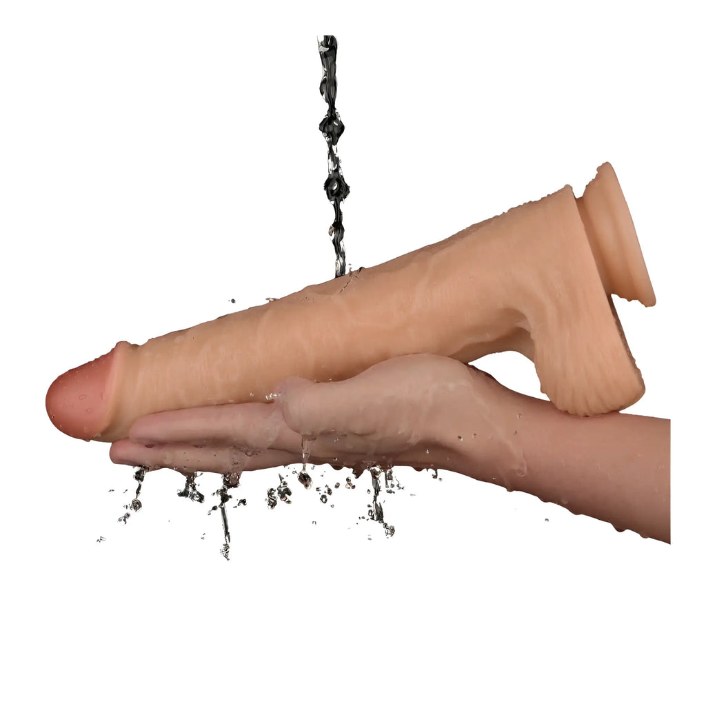 Beige silicone realistic male genital model being rinsed with water from lovetoy 11in vibrating usb power basics cock