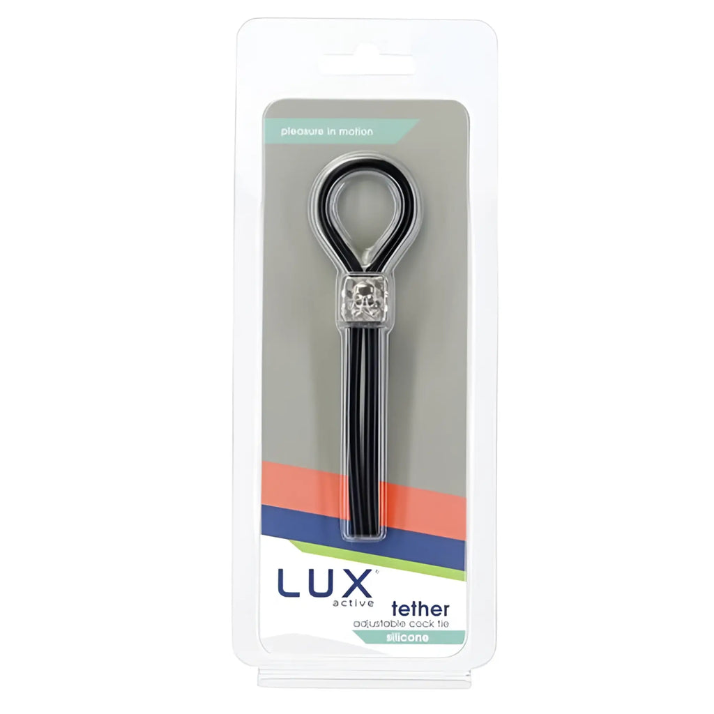 Black silicone adjustable cock tie with silver skull charm inside clear plastic packaging from LUX Active Tether