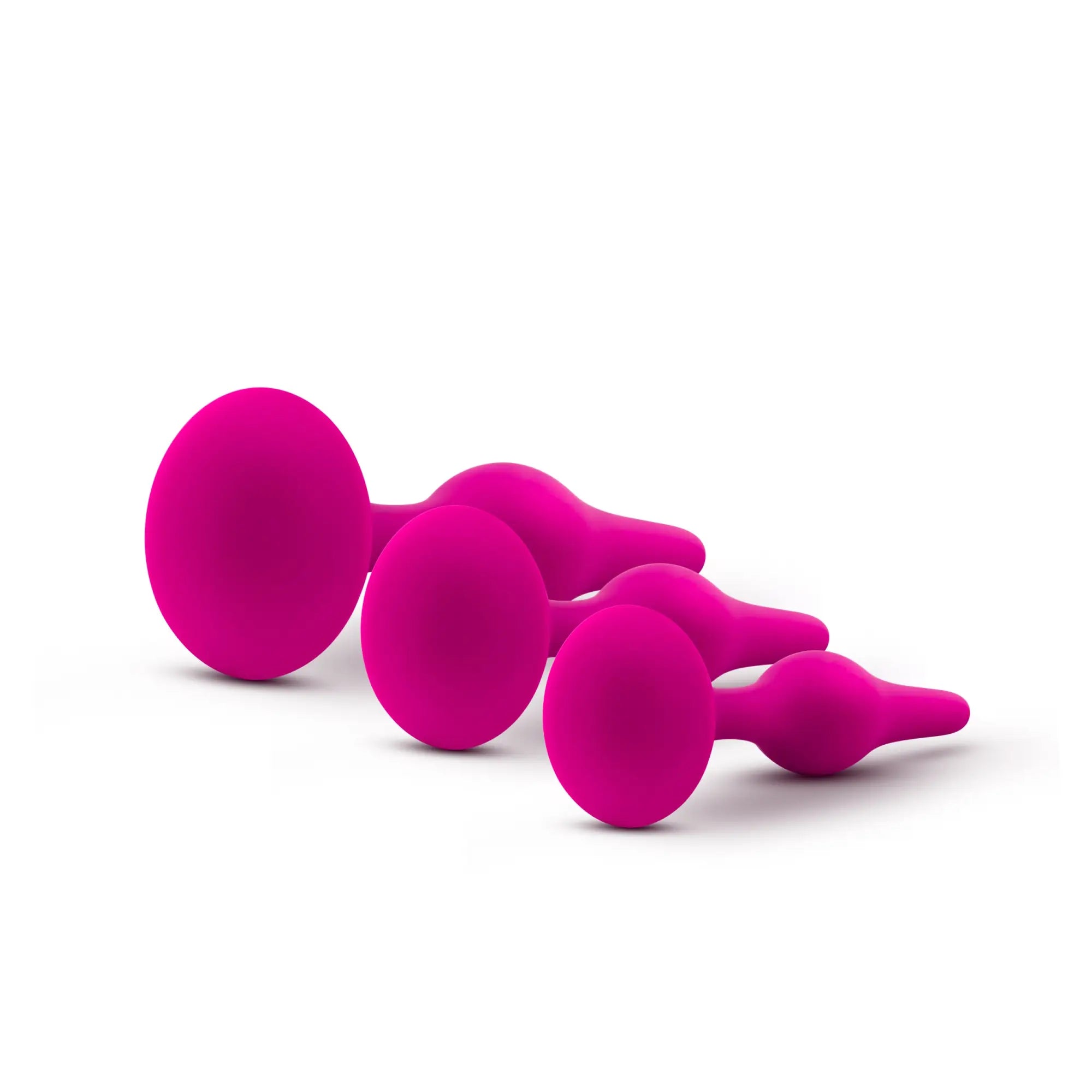 Set of four vibrant magenta silicone anal plugs with smooth rounded heads in luxe luxe beginner plug kit pink