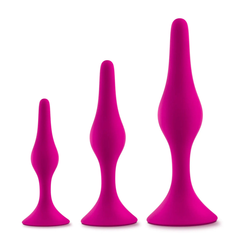 Set of three vibrant fuchsia silicone anal plugs in varying sizes with sleek tapered design from Luxe Luxe beginner kit